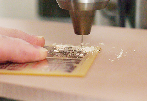 穴あけ加工5：基板の下にベークライト板を敷いて穴あけ作業をする